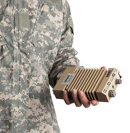 一个穿着军装的人拿着一个棕色的ips - 250 x以太网加密器的特写